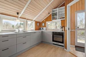 a large kitchen with white cabinets and windows at VE508-Oksbol-Blomstervangen-123 in Oksbøl