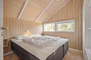 a large bed in a room with a window at VE508-Oksbol-Blomstervangen-123 in Oksbøl