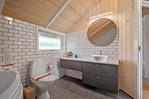 a bathroom with a toilet and a sink and a mirror at VE508-Oksbol-Blomstervangen-123 in Oksbøl +23 photos