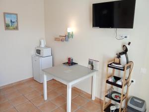a room with a table and a television on the wall at Le Relais du Jardin in Orbigny