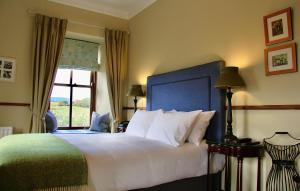 a bedroom with a large white bed and a window at Wild Honey Inn in Lisdoonvarna