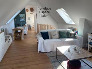 a living room with a couch and a table at Ty Glazu Doelan espace 60m2, Port& criques à pied, 2 chambres privées au 1er étage, SDB, WC séparé in Clohars-Carnoët