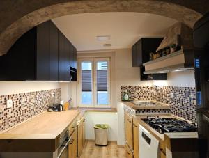 a kitchen with black cabinets and a sink and a stove at Sea Paradise Piran in Piran