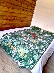 a bed with a blanket with palm trees on it at Ti Caz Bana in Le Tampon +5 photos