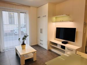 a living room with a flat screen tv at Central Seven Apartman - Free Parking in Győr