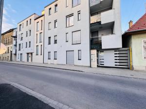 an empty street with white buildings on the side at Central Seven Apartman - Free Parking in Győr