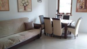 a living room with a couch and a table with chairs at Familienurlaub am See - Haus nr 1 - Rokitki in Rokitki +12 photos