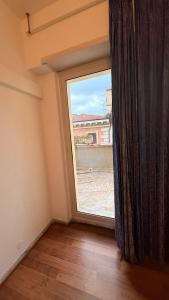 ein leerer Raum mit einem großen Fenster mit Aussicht in der Unterkunft Host Roma in Rom
