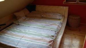 a bed with two pillows on it in a room at Familienurlaub am See - Haus nr 1 - Rokitki in Rokitki