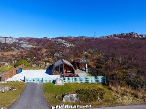 an aerial view of a house on a hill with a road at Selkie Cabin Achmelvich, Lochinver in Lochinver