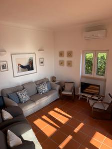 a living room with a couch and a fireplace at Foz - Sea View Cottage in Foz do Arelho +22 photos