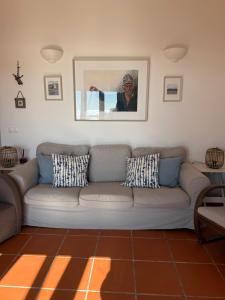 a living room with a couch and a picture on the wall at Foz - Sea View Cottage in Foz do Arelho