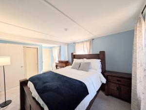 a bedroom with a large bed with a blue wall at The Saco Valley Stay in Conway