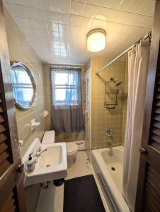 a bathroom with a sink and a toilet and a tub at The Saco Valley Stay in Conway