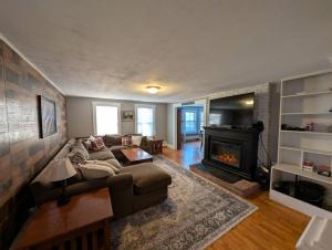 a living room with a couch and a fireplace at The Saco Valley Stay in Conway