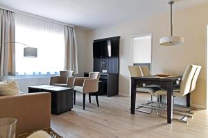 uma sala de estar e sala de jantar com mesa e cadeiras em Hotel Twilling em Böhl