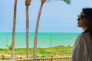 a woman looking out at the ocean and palm trees at Casa Mandala Corumbau in Corumbau