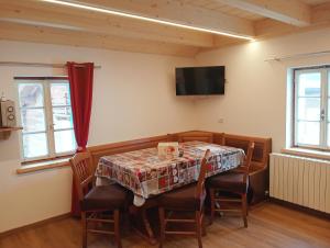 a dining room with a table and chairs and a television at canton 520 appartamenti self check in in Livigno