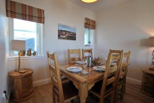 a dining room with a wooden table and chairs at Harbourside Apartment in Anstruther