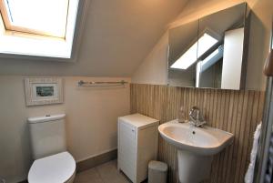 a bathroom with a sink and a toilet and a mirror at Harbourside Apartment in Anstruther +40 photos
