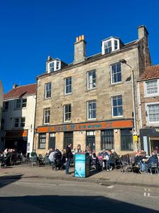 a group of people sitting outside of a building at Harbourside Apartment in Anstruther