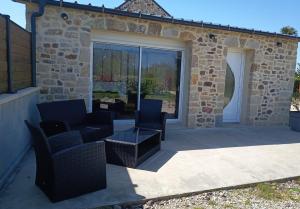 a patio with chairs and a table and glass doors at Chez Mat's & Lou in Rocheville