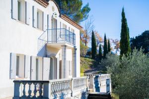 a white building with a balcony on the side of it at Bastide de Valvérane in Manosque