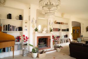 a living room with a fireplace and a chandelier at Bastide de Valvérane in Manosque