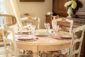 a wooden table with plates and glasses on it at Bastide de Valvérane in Manosque