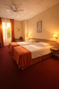 una camera d'albergo con due letti e una finestra di Hôtel Foch a Lione