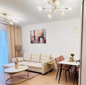 a living room with a couch and a table at Lotus Apartments Impero separate kitchen two rooms parking balcony in Ostrołęka