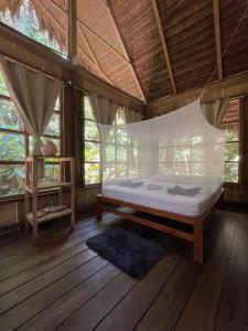 a bedroom with a bed in a room with windows at CHUNAKI ECOLODGES - Authentic Activities and Food in the Amazon in Zaragoza