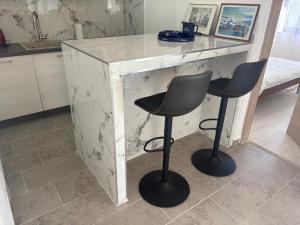 a white marble counter with two chairs in a kitchen at Pag House in Pag +80 photos