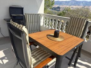 a wooden table and chairs sitting on a balcony at Pag House in Pag