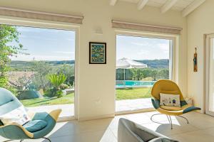 a living room with two chairs and a sliding glass door at Villa dei Gruccioni - YourPlace Abruzzo in Torino di Sangro