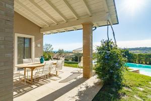a patio with a table and chairs and a pool at Villa dei Gruccioni - YourPlace Abruzzo in Torino di Sangro