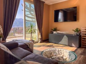 ein Wohnzimmer mit Sofa und großem Fenster in der Unterkunft Villa Lenis - Panoramic Pool in Mandello del Lario