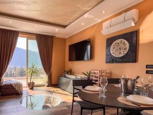ein Wohnzimmer mit Esstisch und ein Wohnzimmer mit Aussicht in der Unterkunft Villa Lenis - Panoramic Pool in Mandello del Lario