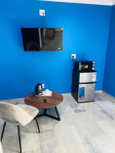 a blue room with a table and a stove at Redem House in Modimolle
