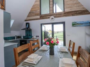 a kitchen with a table with a vase of flowers at Valley View Hideaway in Llandysul