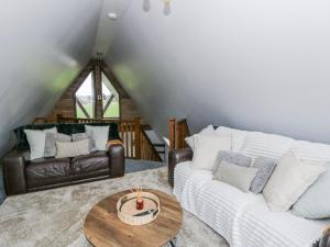 a living room with two couches and a table at Valley View Hideaway in Llandysul