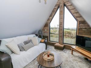 a living room with a white couch and a large window at Valley View Hideaway in Llandysul