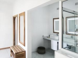 a white bathroom with a sink and a mirror at Duna Serena Tiny Houses in Praia do Tofo +33 photos