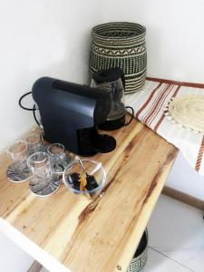 a coffee maker on a table with glasses on it at Duna Serena Tiny Houses in Praia do Tofo