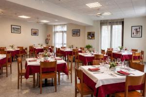 a dining room with tables and chairs with red tablecloths at El Mensario in Campisábalos