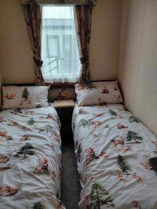 a small room with two beds and a window at Holiday Home in Forfar