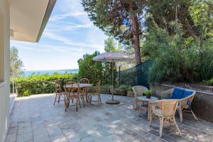 a patio with a table and chairs and an umbrella at Villa Elvise - YourPlace Abruzzo in Fossacesia