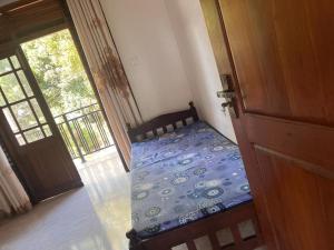 a bedroom with a bed in a room with a door at Dissanayaka house in Nikawatawana