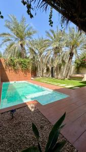 a swimming pool in a yard with palm trees at مجموعة سدرة فاطمة in Al Ahsa