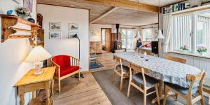 a dining room with a table and a red chair at VE361-Vejers-Strand-Violvej-4 in Vejers Strand